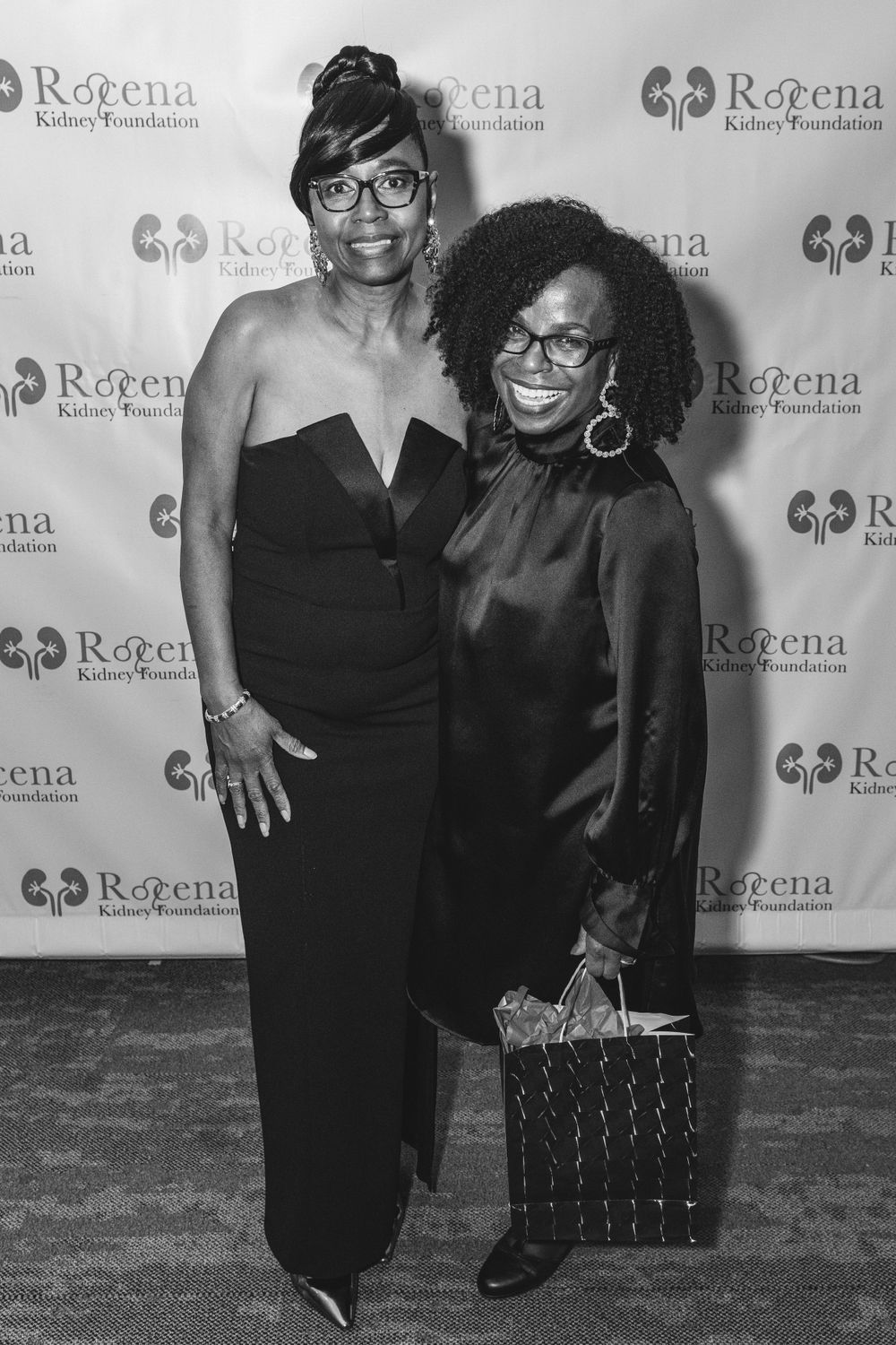 Two people in formal black attire at Rogena Foundation event.