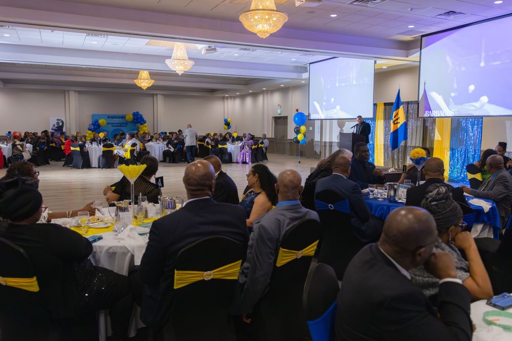 A large banquet hall setup with round tables and blue decor for an evening event.