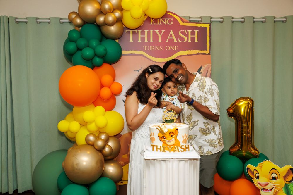 Celebration moment at a Lion King themed first birthday party with balloon arch decorations.
