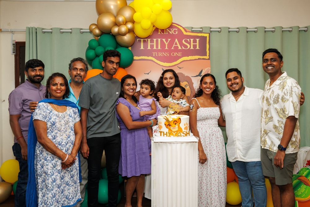 Family gathering with colorful balloon decorations and Lion King themed party backdrop.