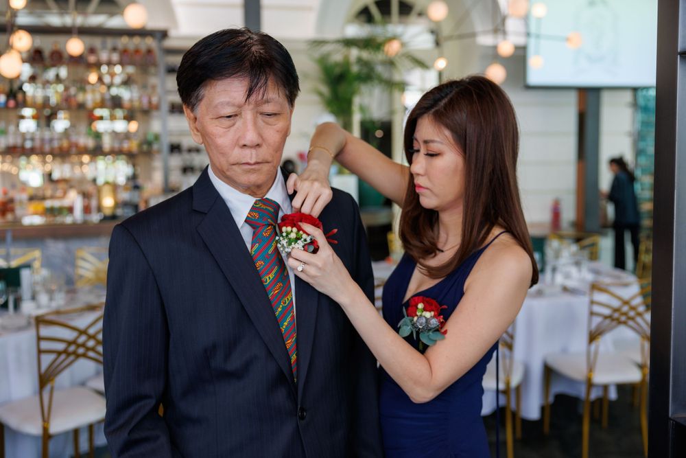 A corsage pinning moment captured at a formal event with participants in blue and dark formal wear.