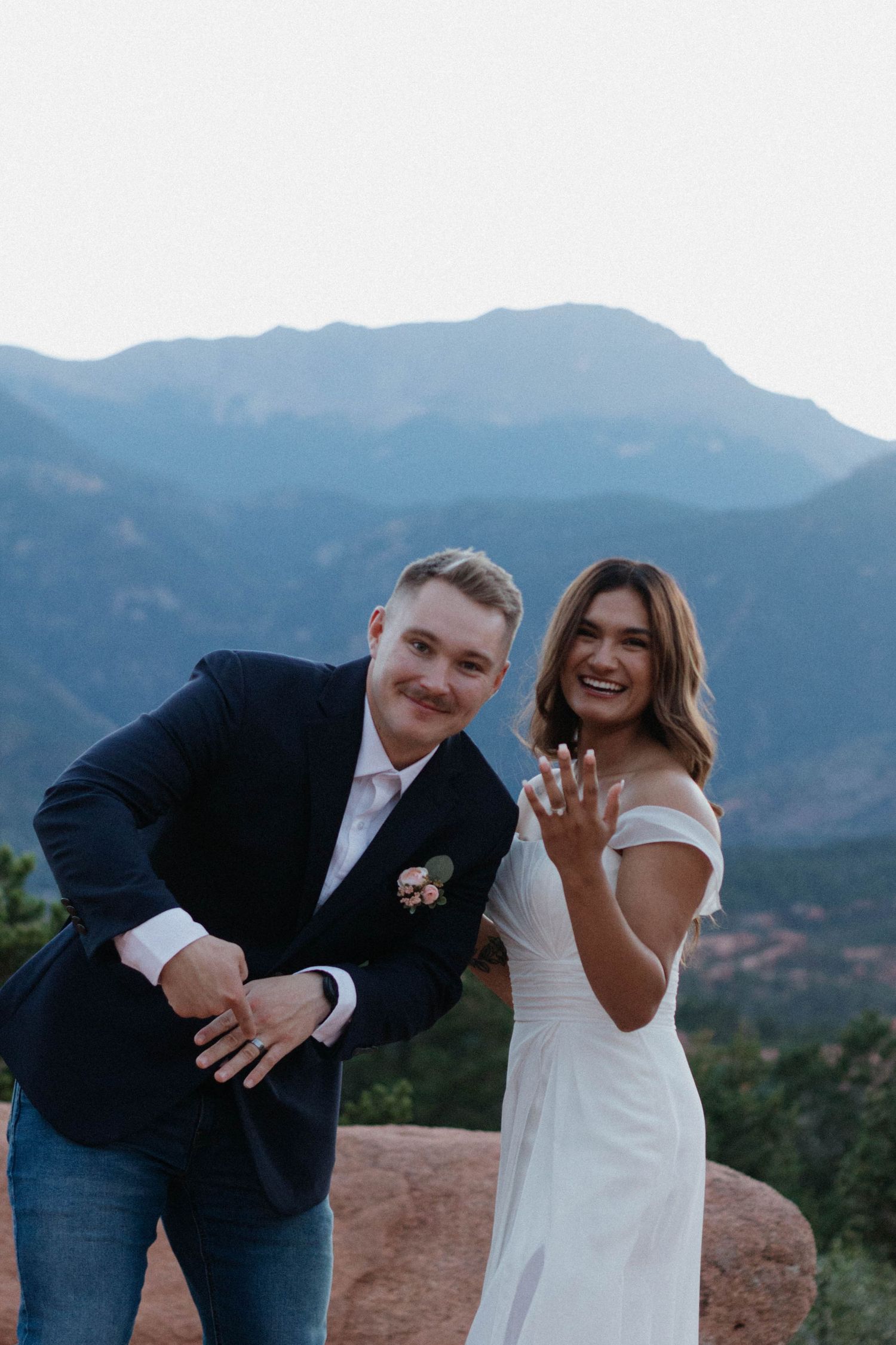 A couple celebrates their engagement in front of mountain views at Garden of the Gods in Colorado. Elopement at Garden of the Gods.