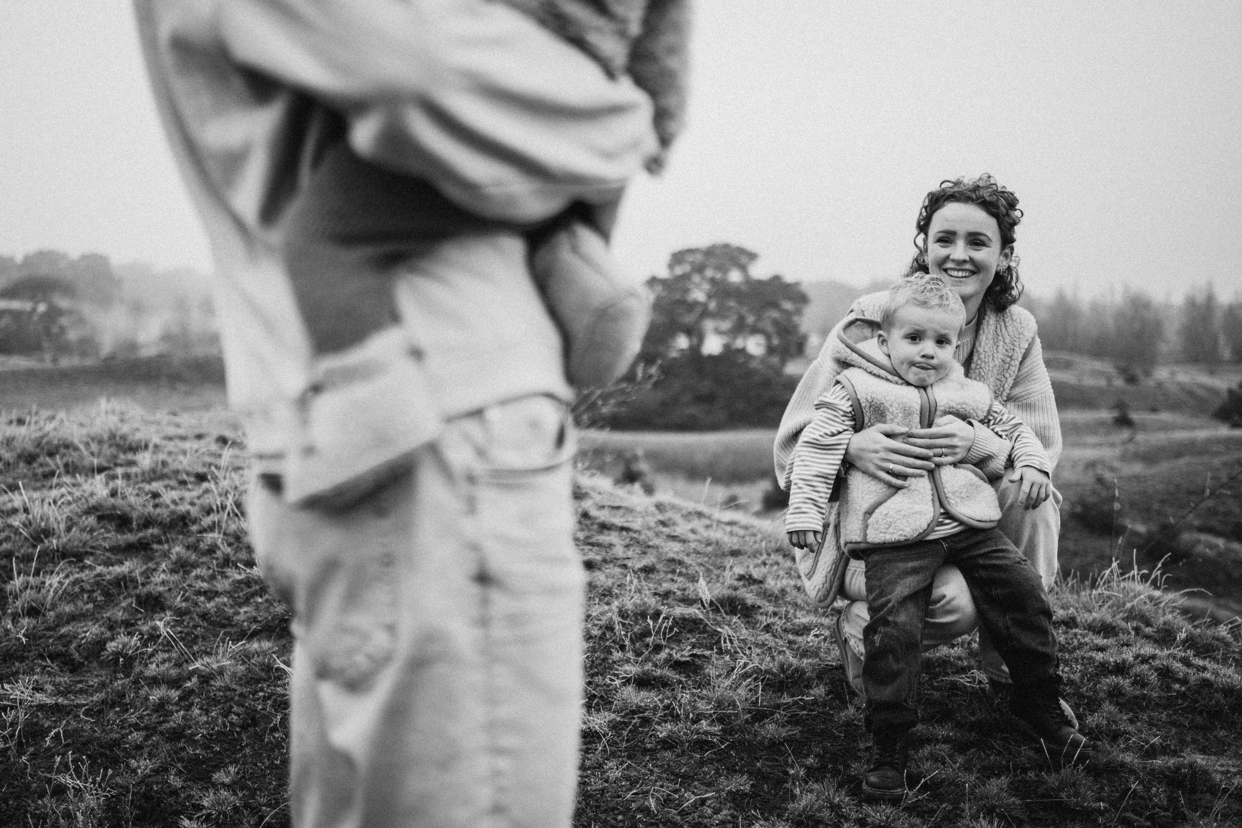 Candid black and white photograph capturing joyful interaction outdoors.