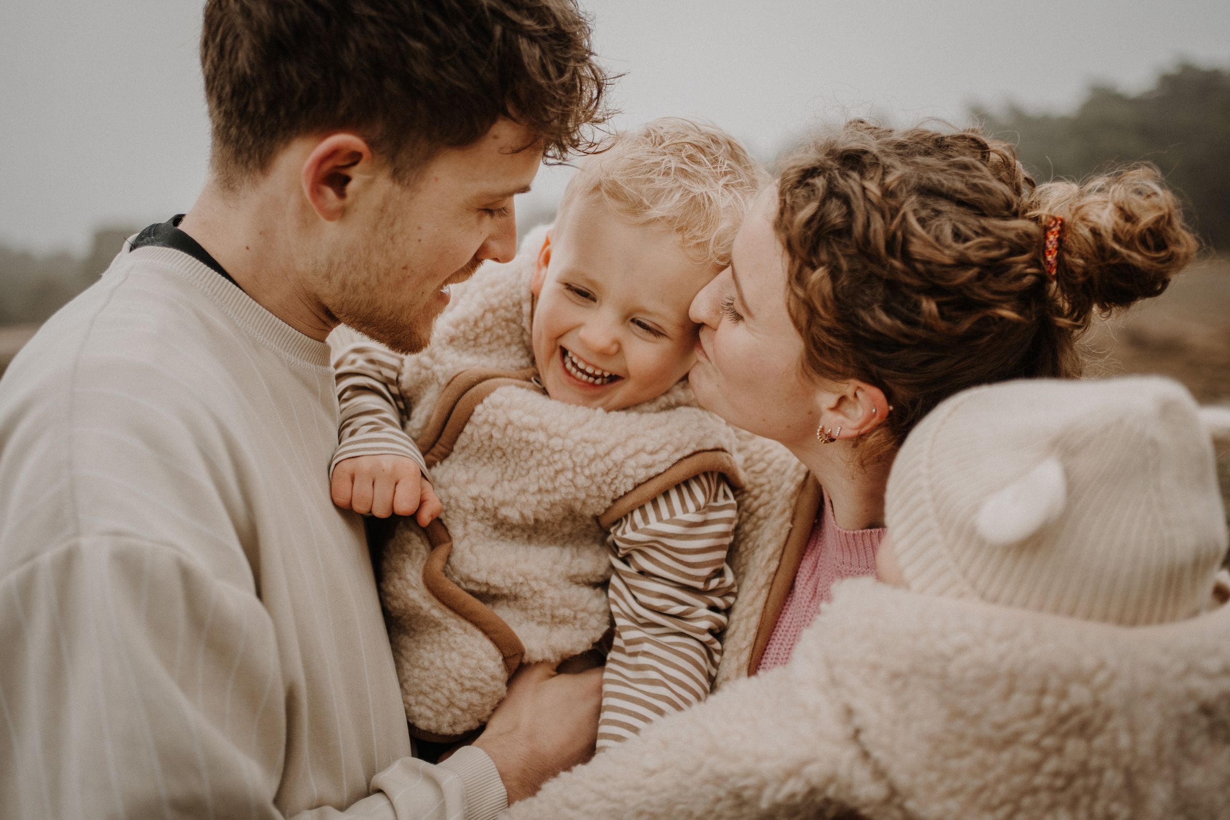 Intimate family moment captured in warm tones during outdoor photoshoot.