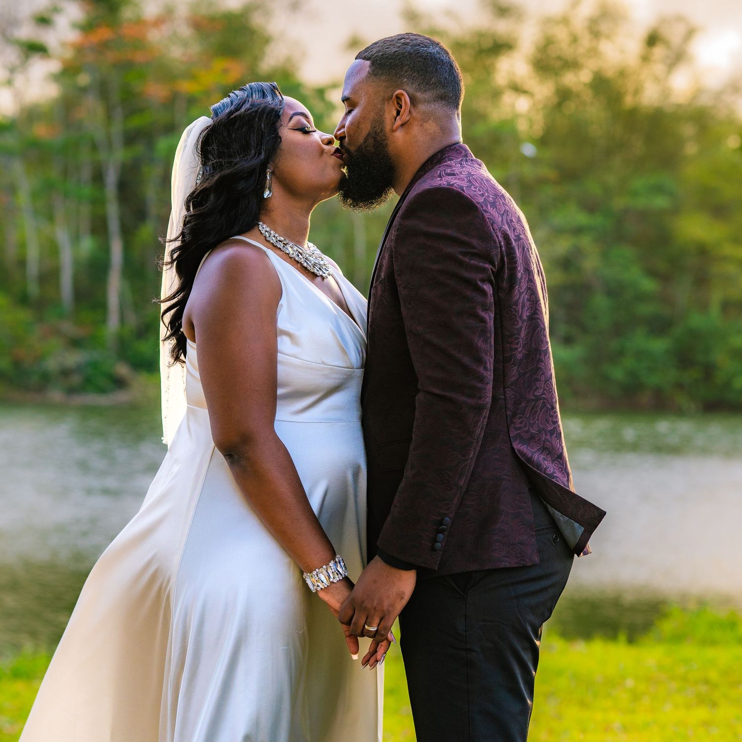 An intimate wedding portrait showing a tender moment between a couple in an outdoor natural setting.