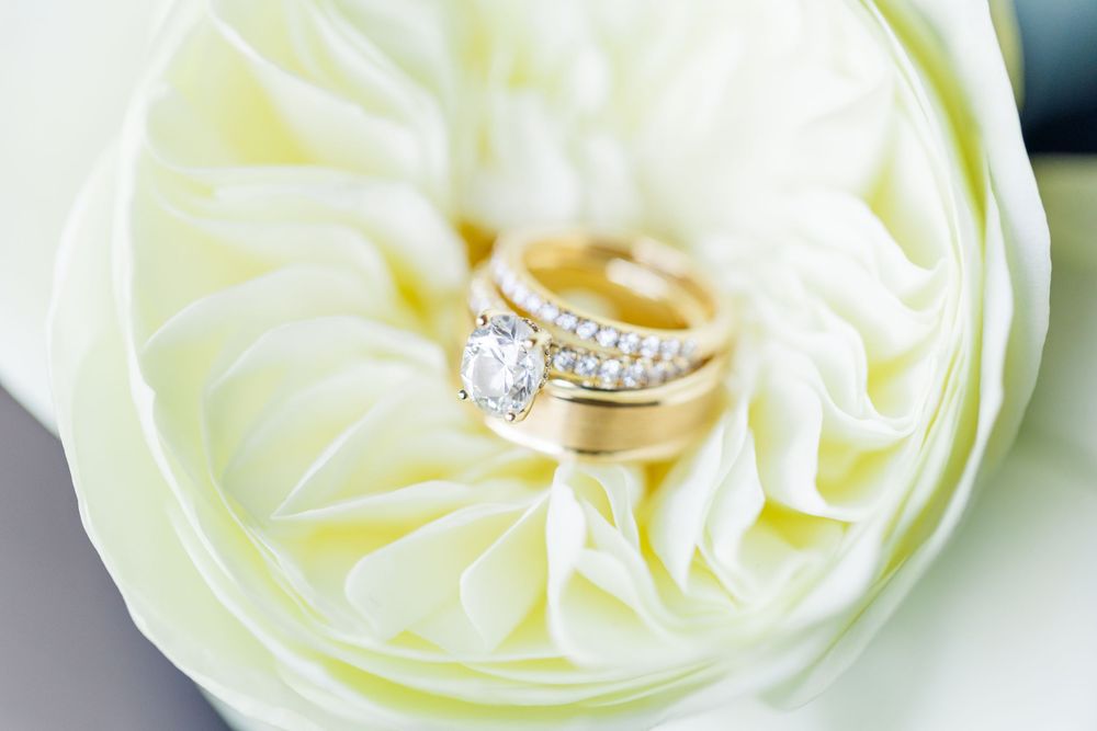 Wedding rings nestled in the center of a white flower blossom.