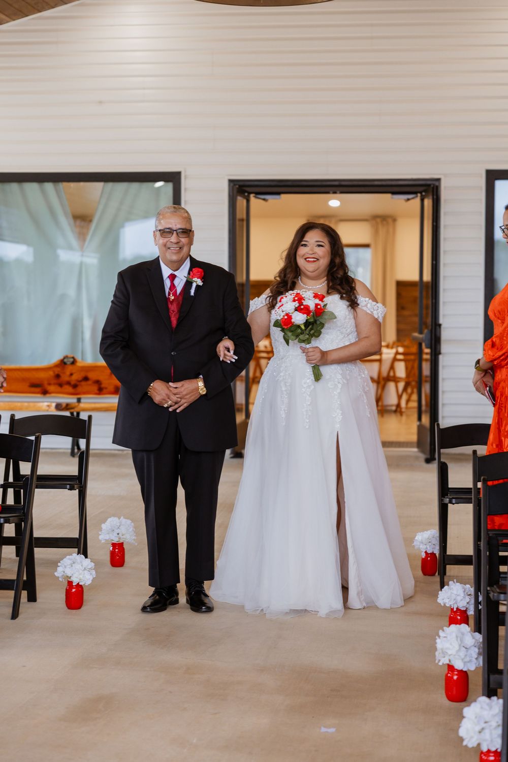A wedding processional sequence showing a bride walking down the aisle in a white gown with red floral accents.