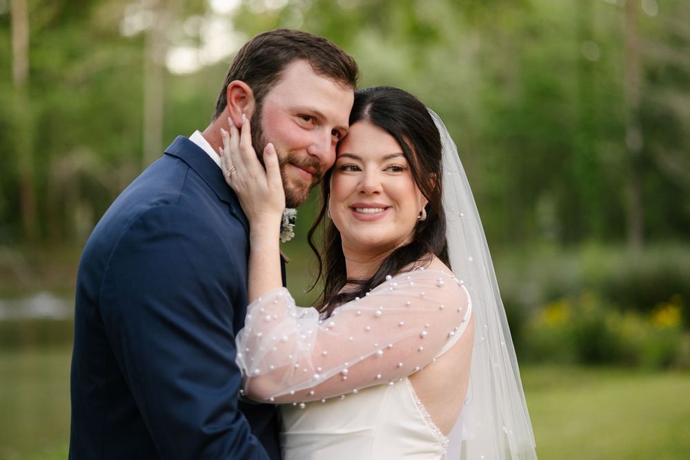 A romantic wedding couple shares intimate moments in a lush garden setting during their outdoor photo session.