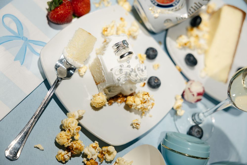 Overhead view of fresh berries, cheese, crackers, and blueberries scattered on a light blue surface.