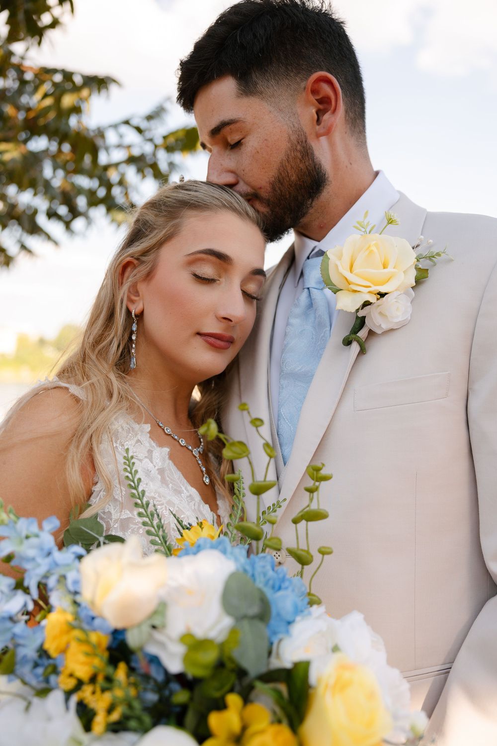 A romantic outdoor wedding scene with cream and blue florals against a sunlit backdrop.