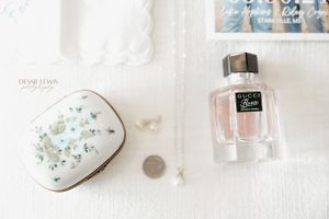 Floral trinket box and perfume bottle arranged on white surface.
