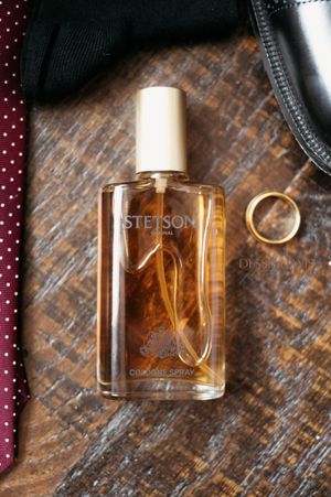 Stetson cologne bottle on wooden surface with accessories.