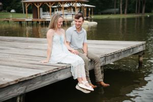Couple sitting casually on wooden dock by lake