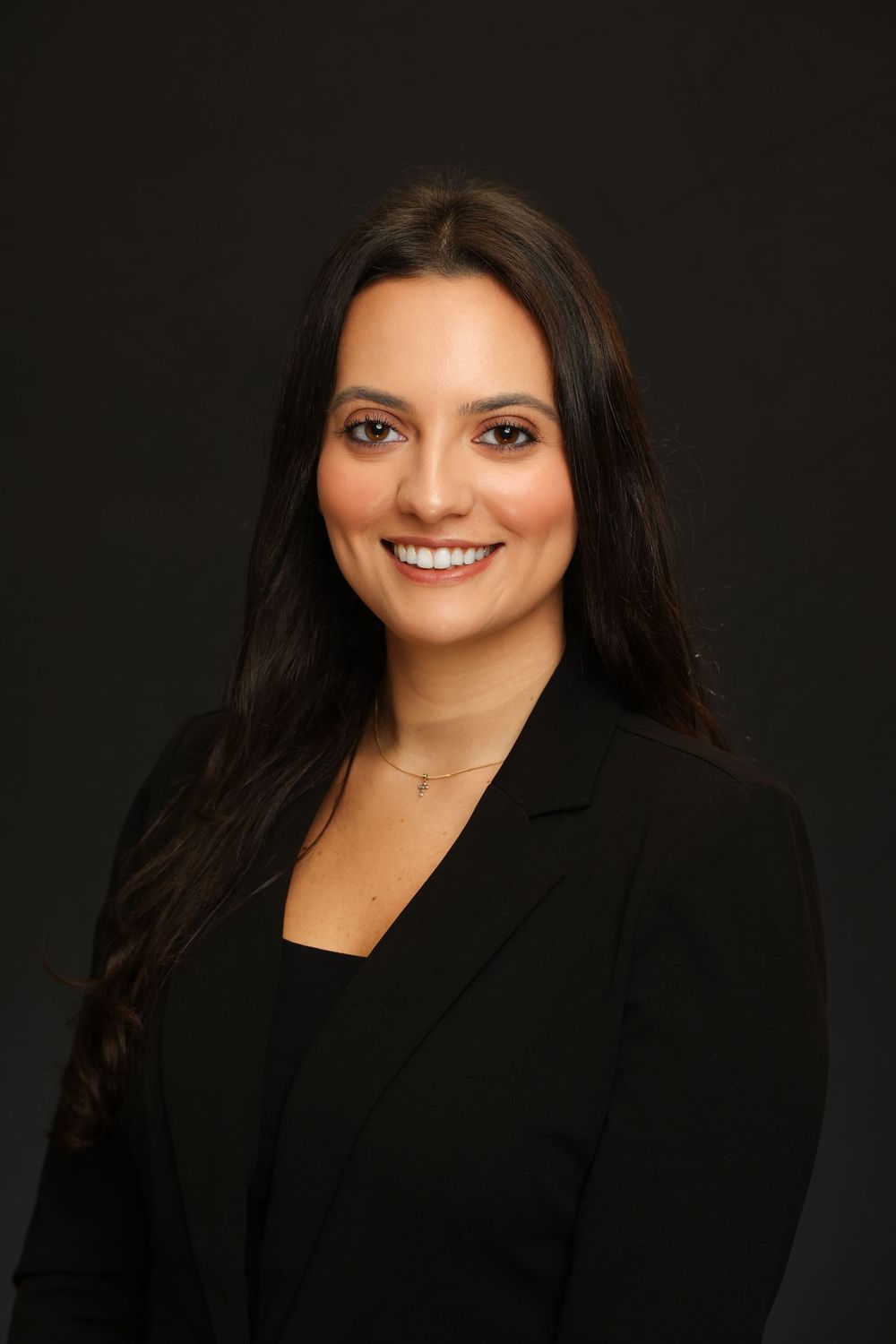 Professional headshot portraits against dark background showing warm smiles and black business attire.