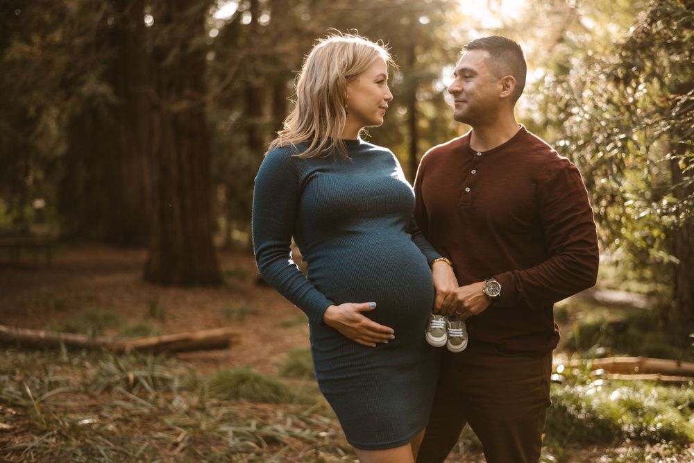 Candid maternity photography showing joyful moments in nature.