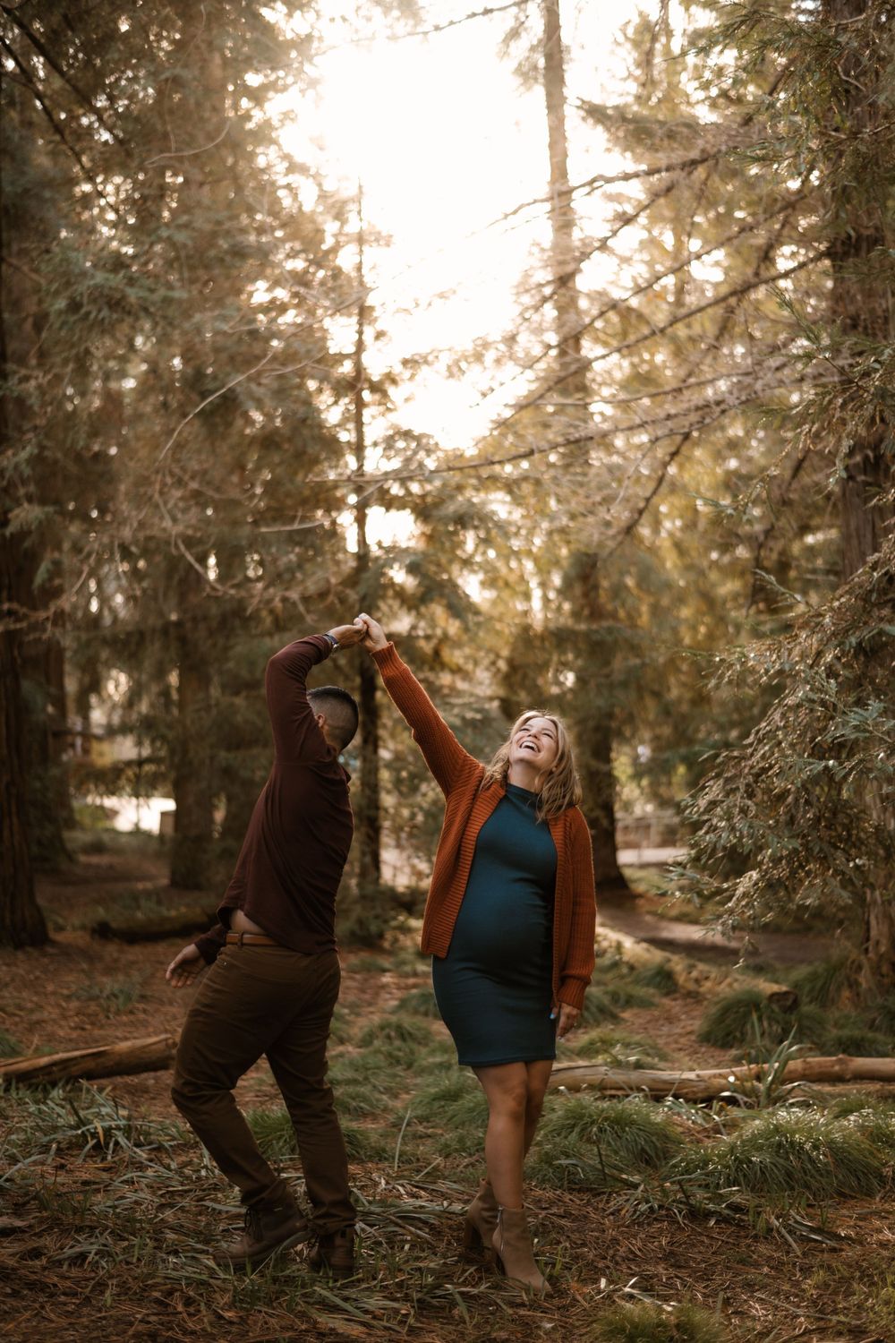 Fun and energetic maternity photos captured in a wooded setting.
