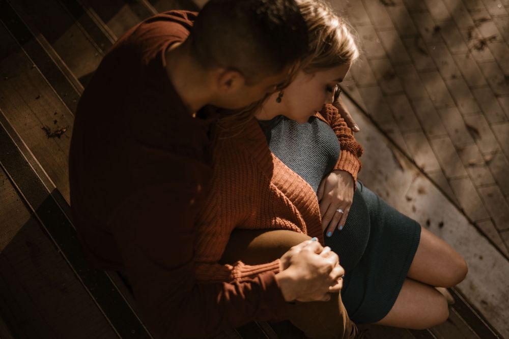 Artistic maternity photos captured in dramatic low-light setting.