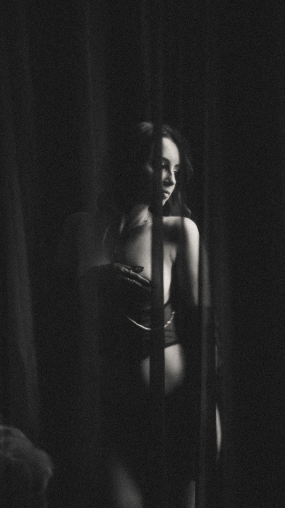 Moody black and white photography with dramatic shadows and curtains.