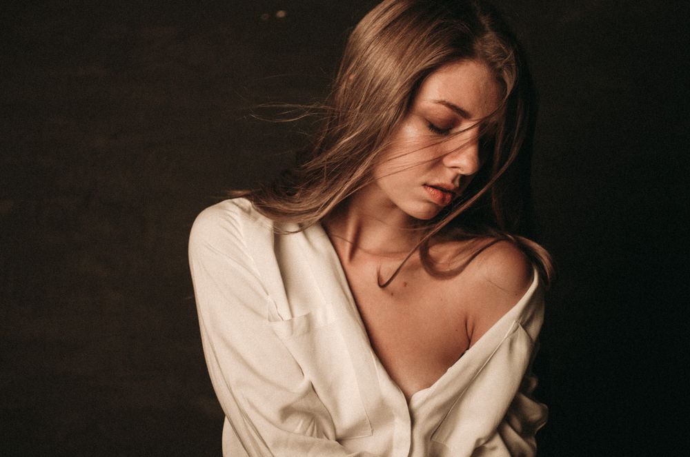 Intimate portrait in white shirt with soft natural lighting against neutral background.