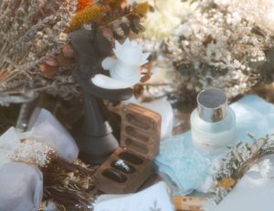 Wedding decor details featuring dried flowers, ceramic items and vintage accessories on a blue surface.