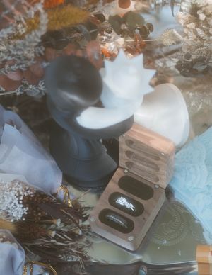 A dreamy, filtered photo of an engagement ring box surrounded by soft floral arrangements.