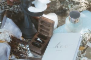Wedding details featuring a ring box and vows book arranged with delicate styling.