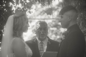 A black and white ceremony photo capturing the exchange of vows.