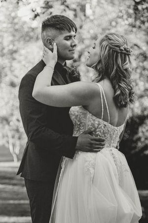 An intimate black and white portrait of a couple in wedding attire.