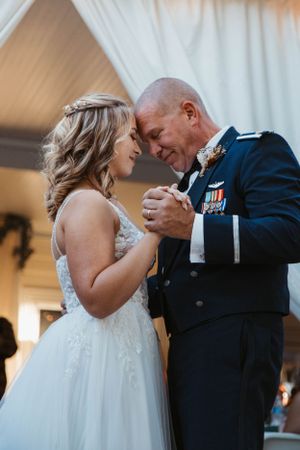An emotional dance moment at a military wedding celebration.