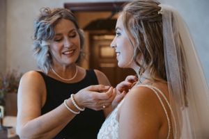 Two women share an intimate moment while getting ready for a wedding ceremony.
