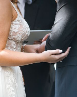 Close-up of hands touching during a wedding ceremony.
