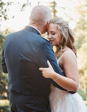 A tender moment captured between newlyweds during an intimate dance at their wedding.
