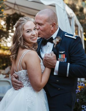 A tender moment shared during a military wedding celebration.