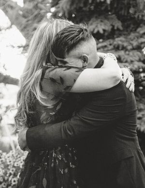 An emotional black and white photograph capturing an intimate embrace at a wedding.