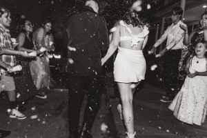 People dancing at a party with confetti falling in black and white photography.