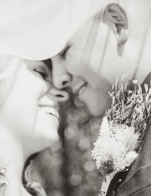 A romantic black and white photograph showing a tender moment with a dried flower bouquet.