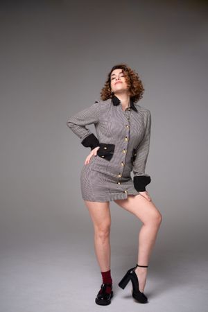 Artistic fashion photo featuring gray patterned jacket and platform shoes in studio setting.