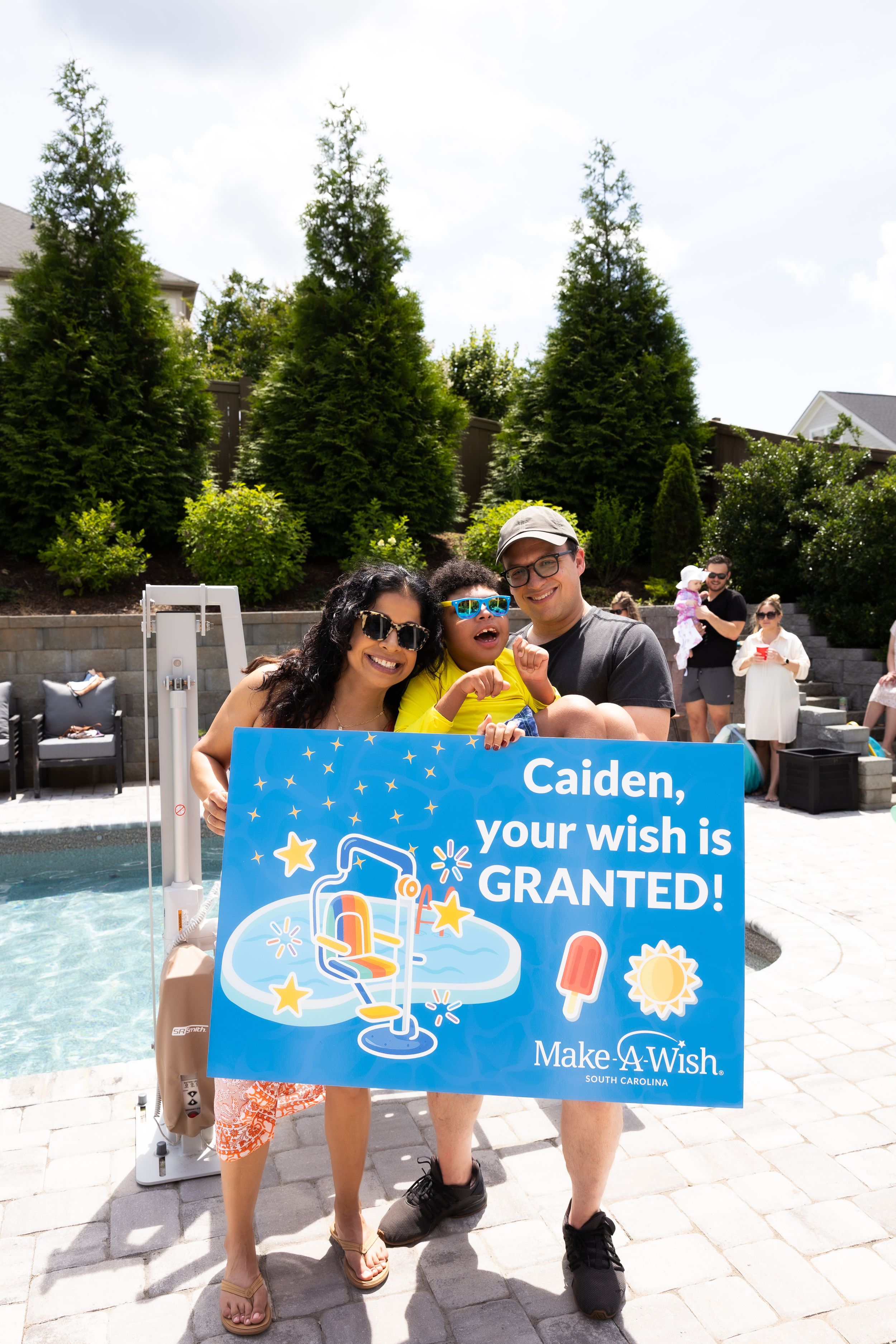 Make-A-Wish celebration gathering by a backyard pool with decorative landscaping in spartanburg, sc