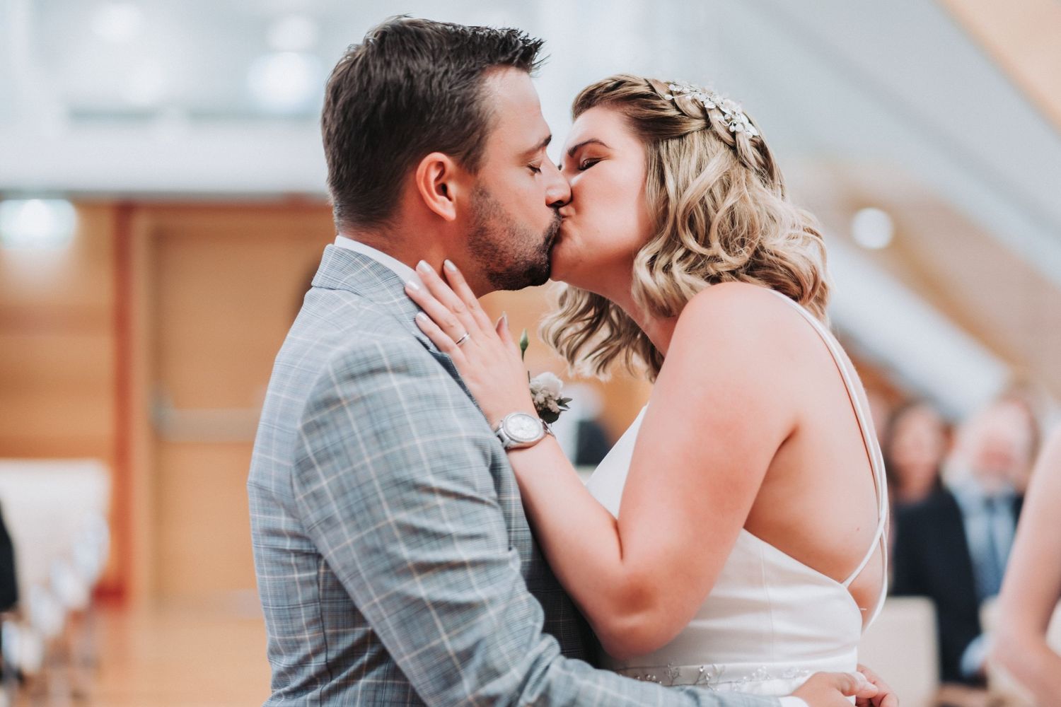 Intimate moment captured as newlyweds share passionate kiss during wedding celebration.