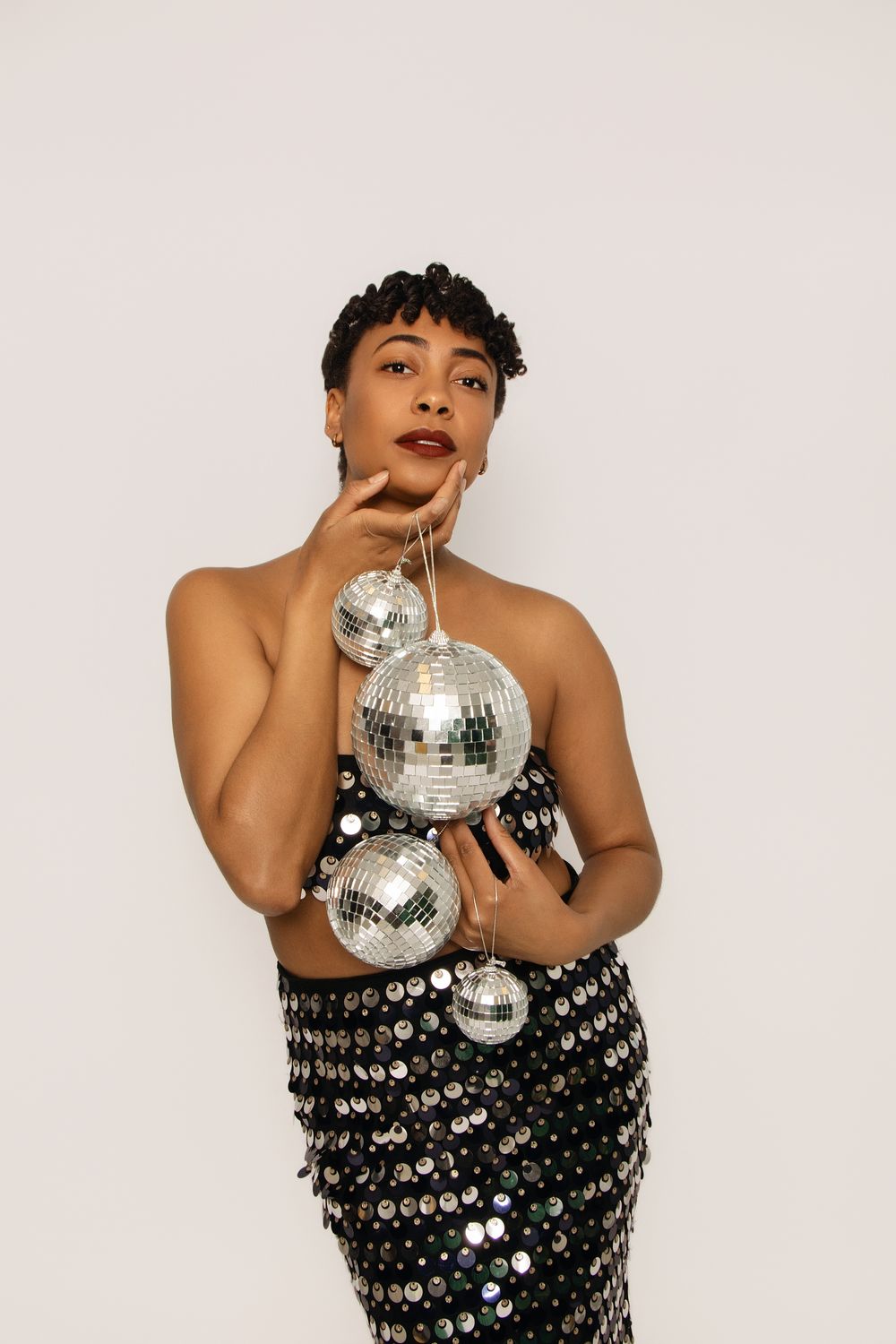 Glamorous studio shots with mirror balls and sparkly sequined dress.