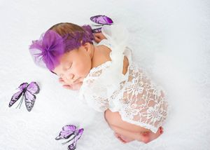 Sleeping baby wrapped in white lace with decorative purple butterflies arranged around them. #NewbornPhotography #CarlsbadNM #NewMexico