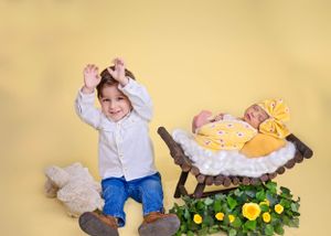 A toddler poses newborn sibling and yellow flowers#newbornphotography #babypictures #newbornphotographer #carlsbadNM #RosewellNM #artesiaNM