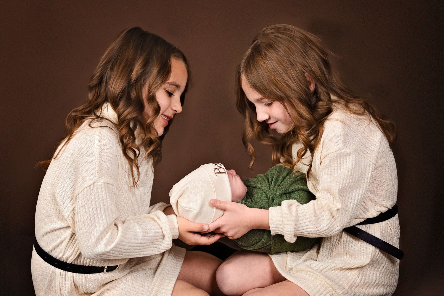 Two siblings hold newborn brother sibling newborn session with siblings in studio in Carlsbad New Mexico. Newborn Photography. Roswell NM