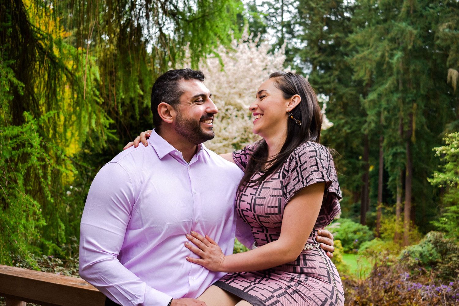 Cozy Garden Couple Portrait
Couple holding each other close in a serene garden scene, surrounded by towering evergreens.