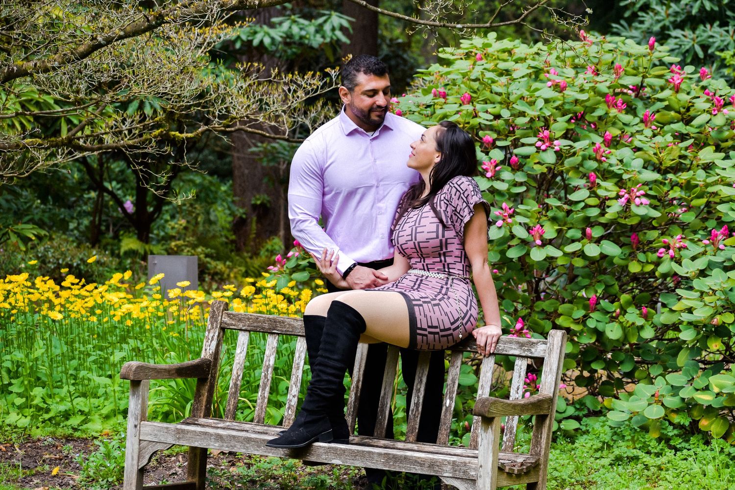 Engagement Bench Portrait in Bloom
Charming engagement photo of a couple seated on a wooden bench surrounded by spring flowers.