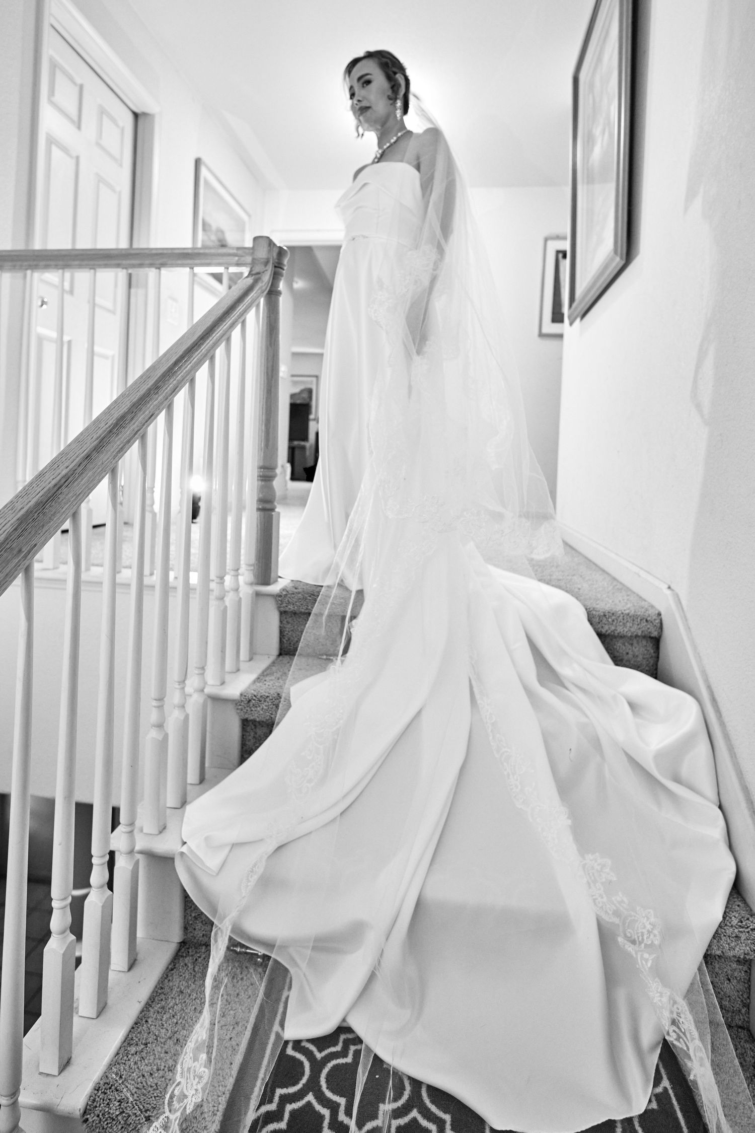 Bride standing at the top of a staircase. Black and white photo.
