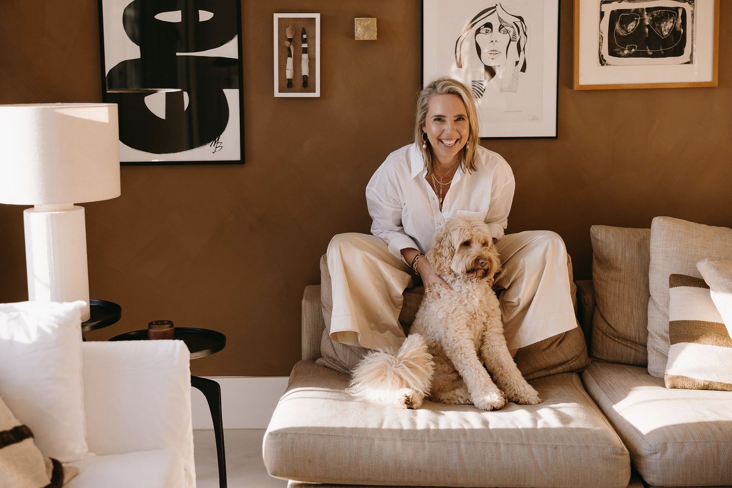 Cozy home scene with golden retriever dog on beige sofa with modern wall art.