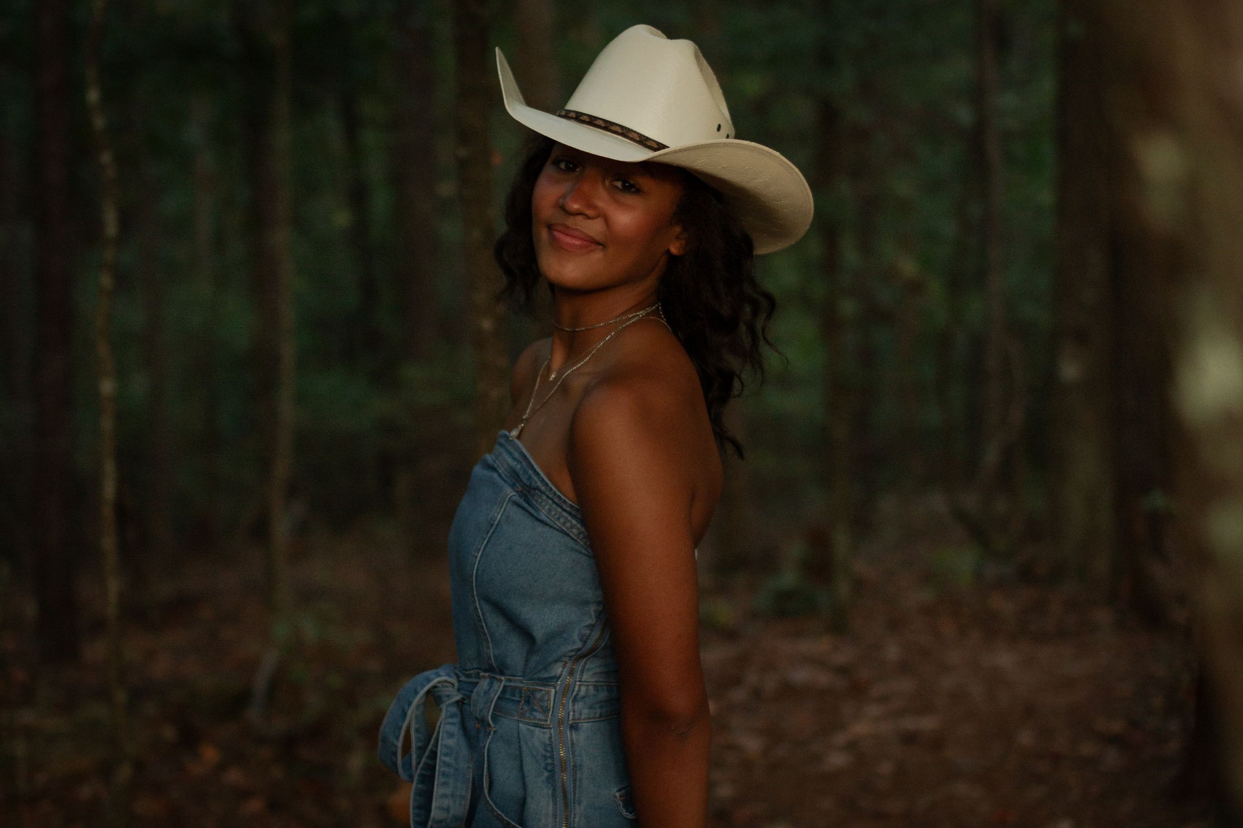Girl in cowboy hat in woods