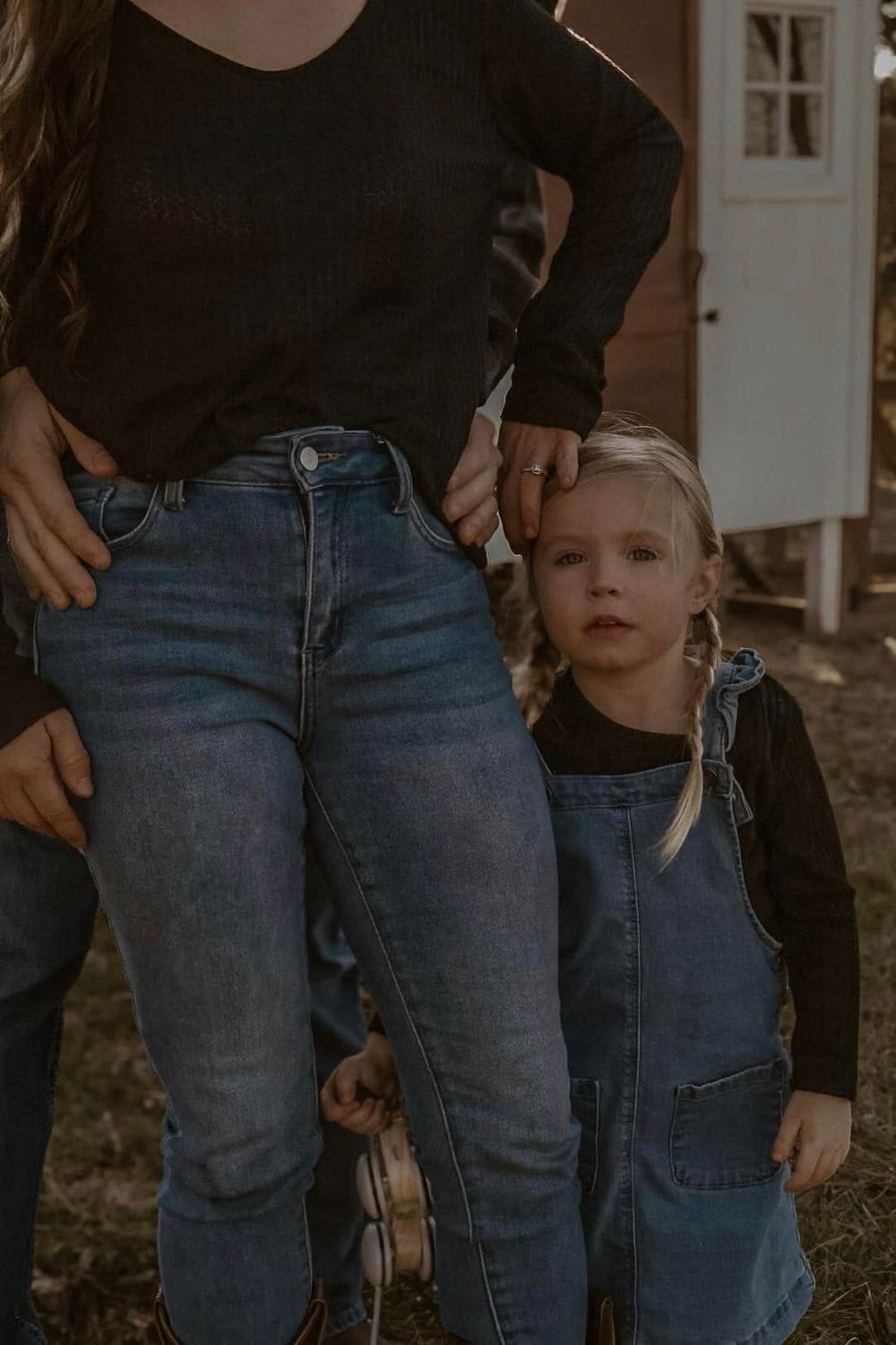 Close-up shot of people wearing denim jeans standing together outdoors.