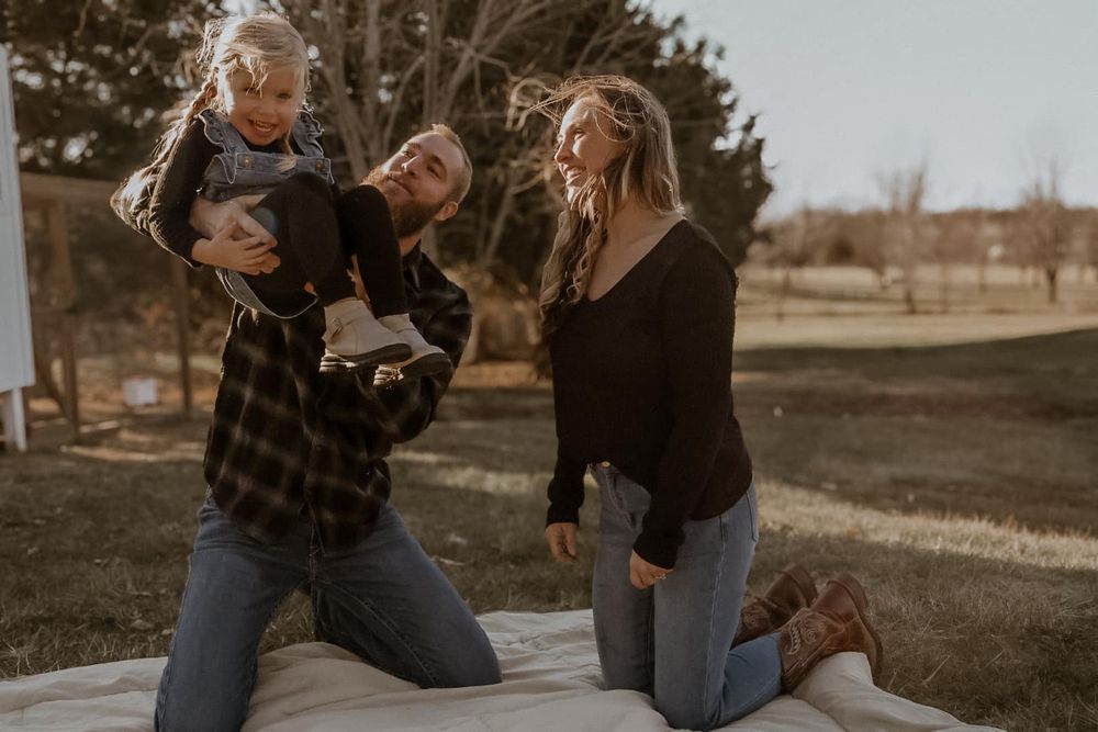 A joyful outdoor family moment captured in warm evening light.